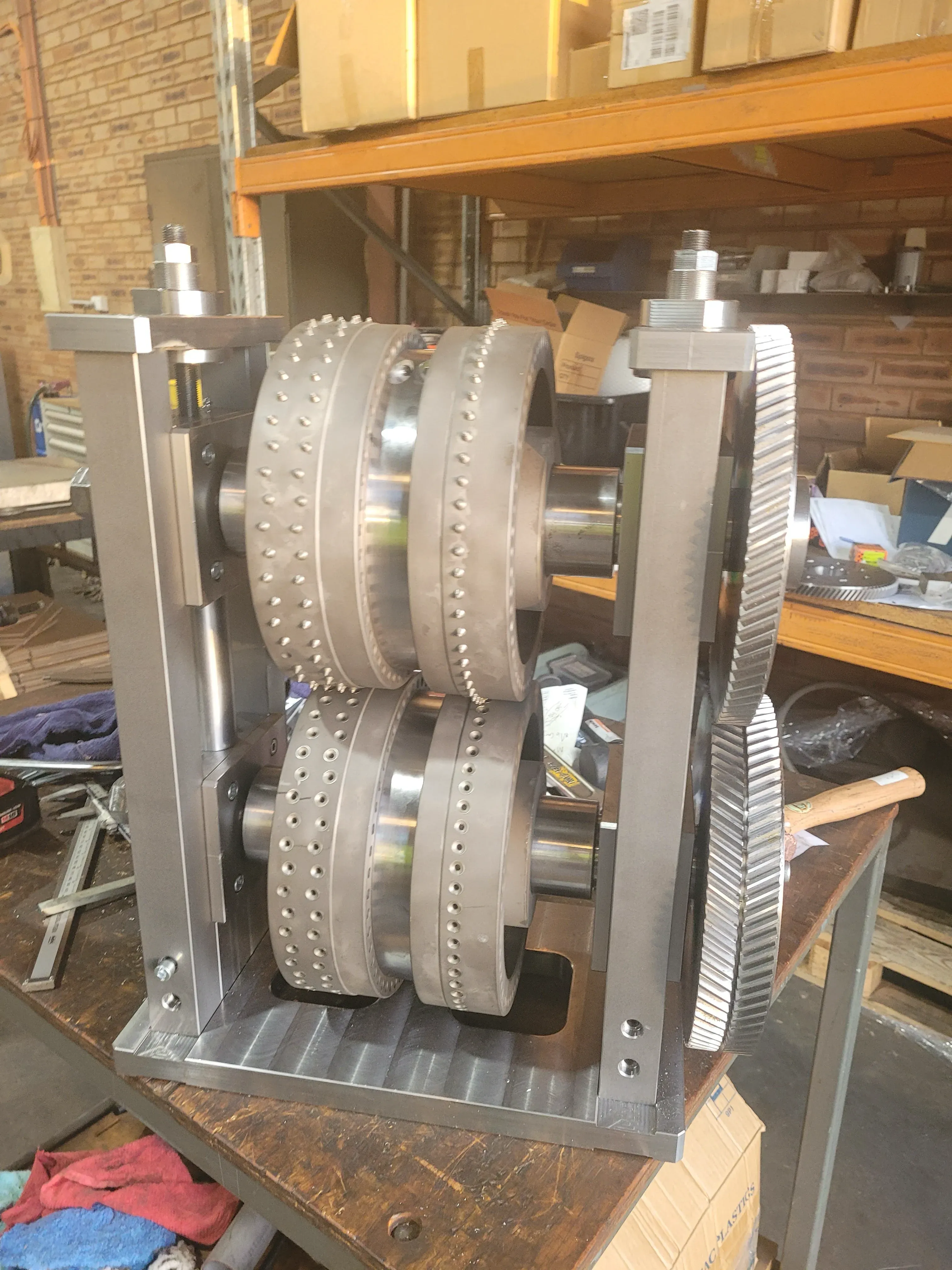 Studded roller assembly and drive gear mounted in a machined frame
