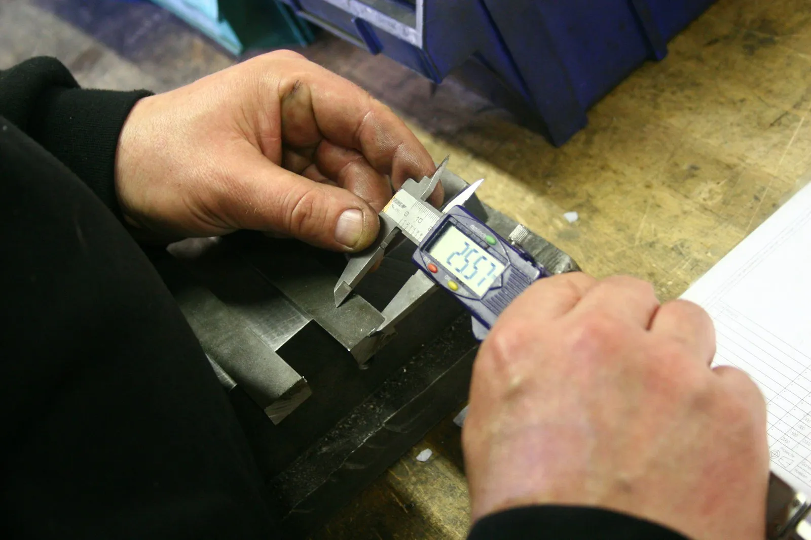 A digital caliper measuring a precision-machined metal component